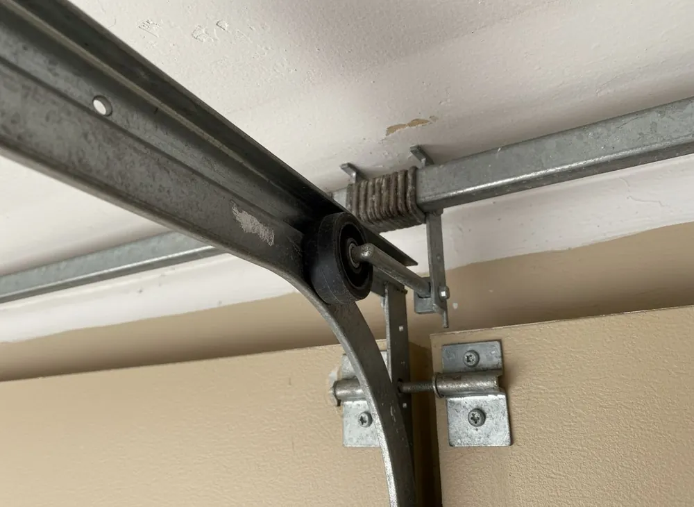 Close view of a nylon roller sitting back inside the curved section of garage door track